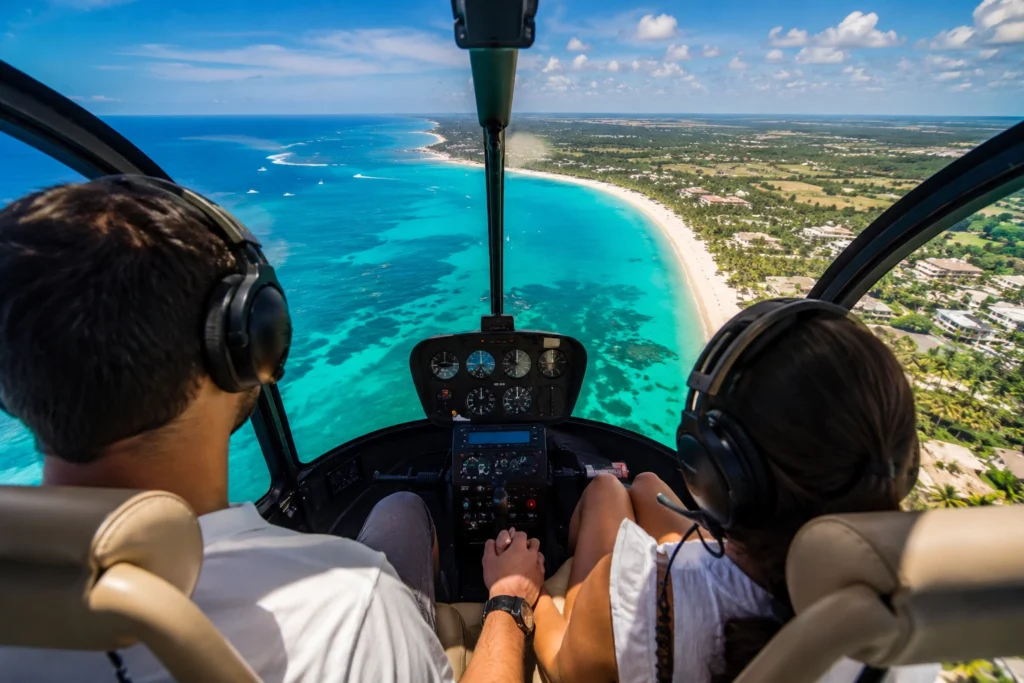 Couple enjoying a helicopter tour over Punta Cana with turquoise Caribbean water, white sand beaches, palm trees, and panoramic coastal views.