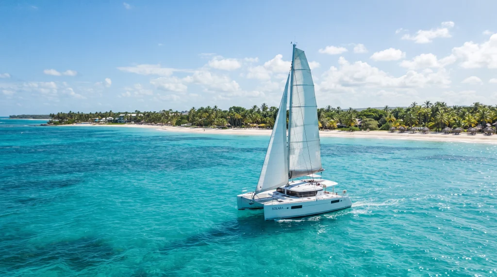 White catamaran sailing on turquoise water near a tropical beach in Punta Cana, Dominican Republic.