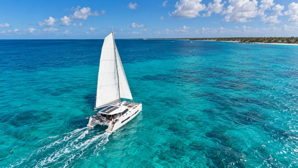 Punta Cana catamaran rental sailing across the turquoise Caribbean Sea, with spacious decks and beautiful tropical coastline views.