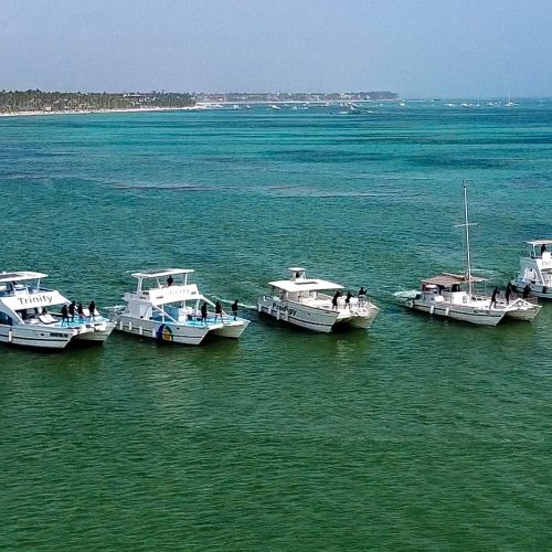 Catamarans sailing in the ocean near Punta Cana with clear blue water and tropical Caribbean coastline